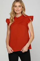 Woman wearing a red blouse with ruffled sleeves
