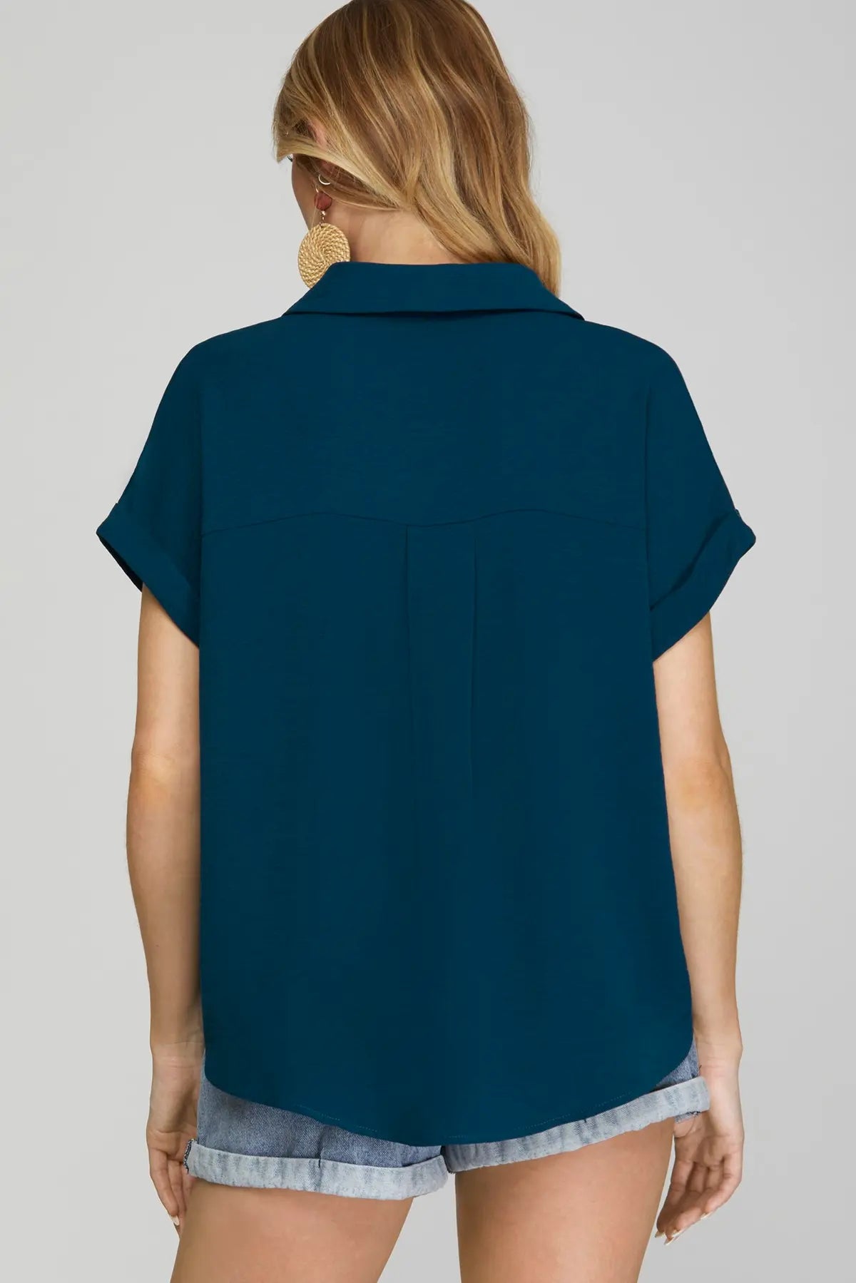 Back of woman wearing a teal drop shoulder collared woven top