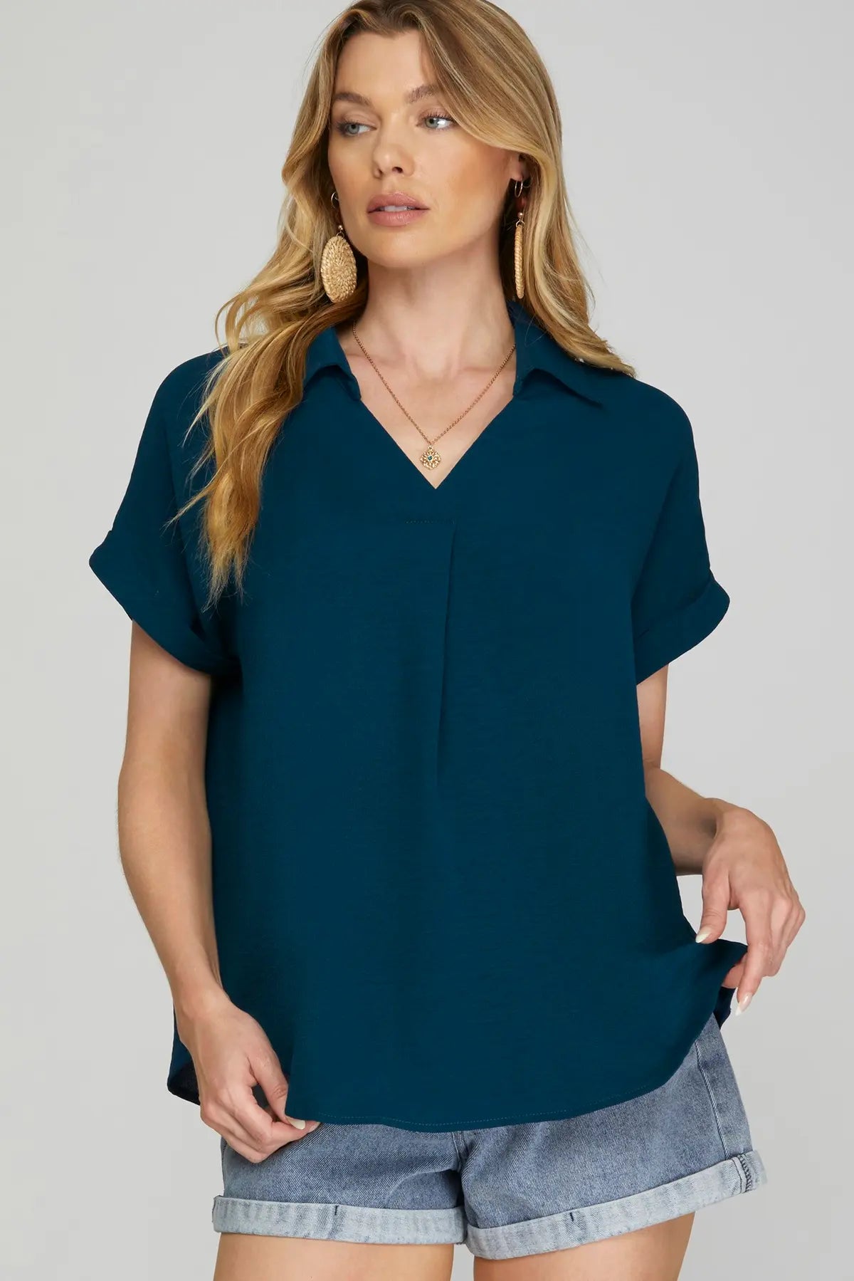 Woman wearing a teal drop shoulder collared woven top
