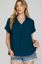 Woman wearing a teal drop shoulder collared woven top