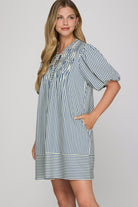 Woman wearing a striped dress against a plain background