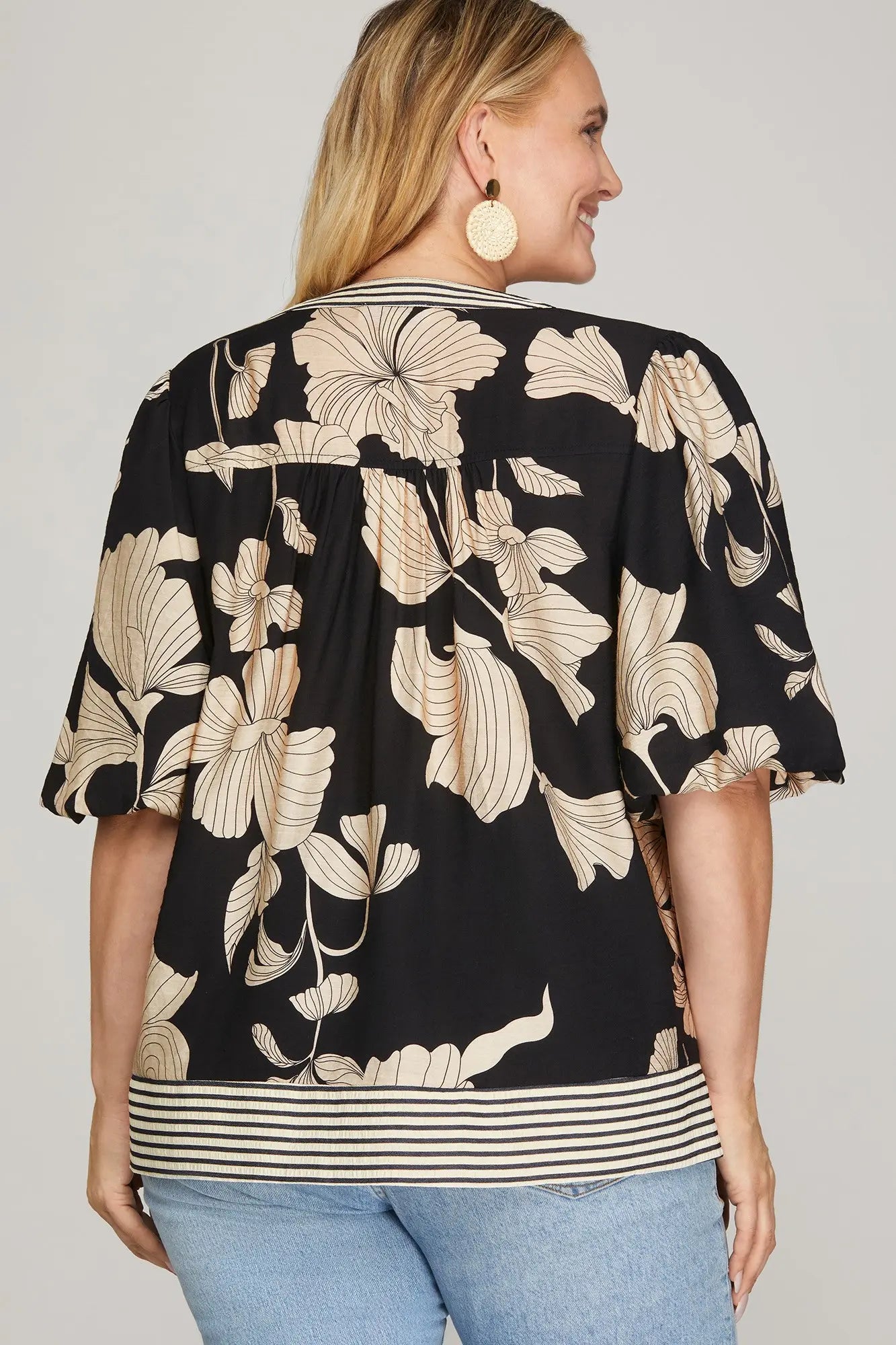 Back view of Woman wearing a black floral patterned top 