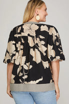 Back view of Woman wearing a black floral patterned top 