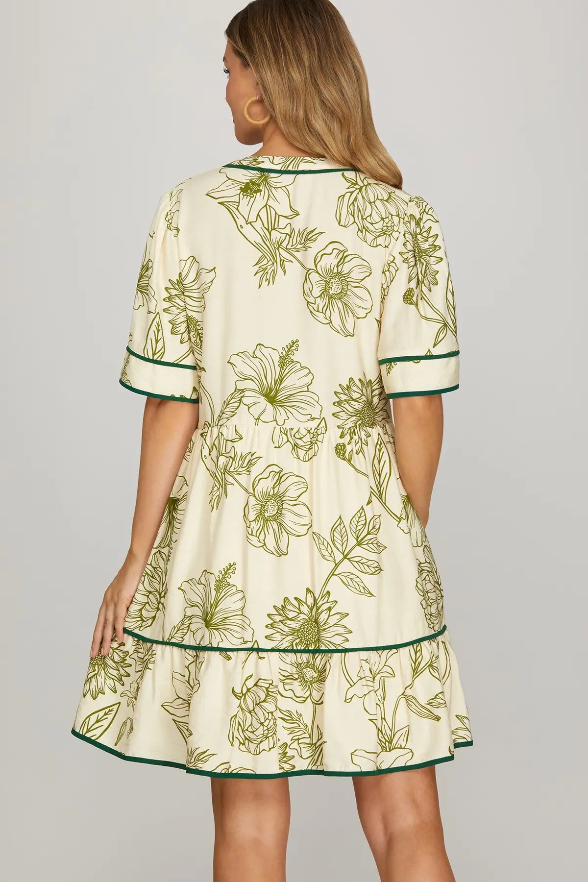 Back of woman wearing a floral dress with green details