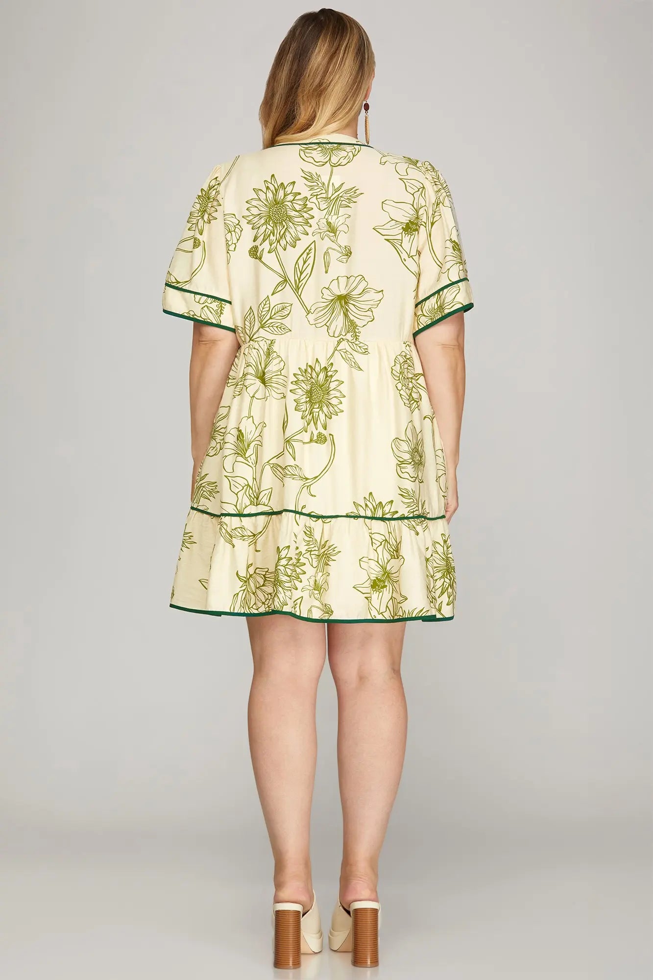 Back of woman wearing a floral dress with green accents 