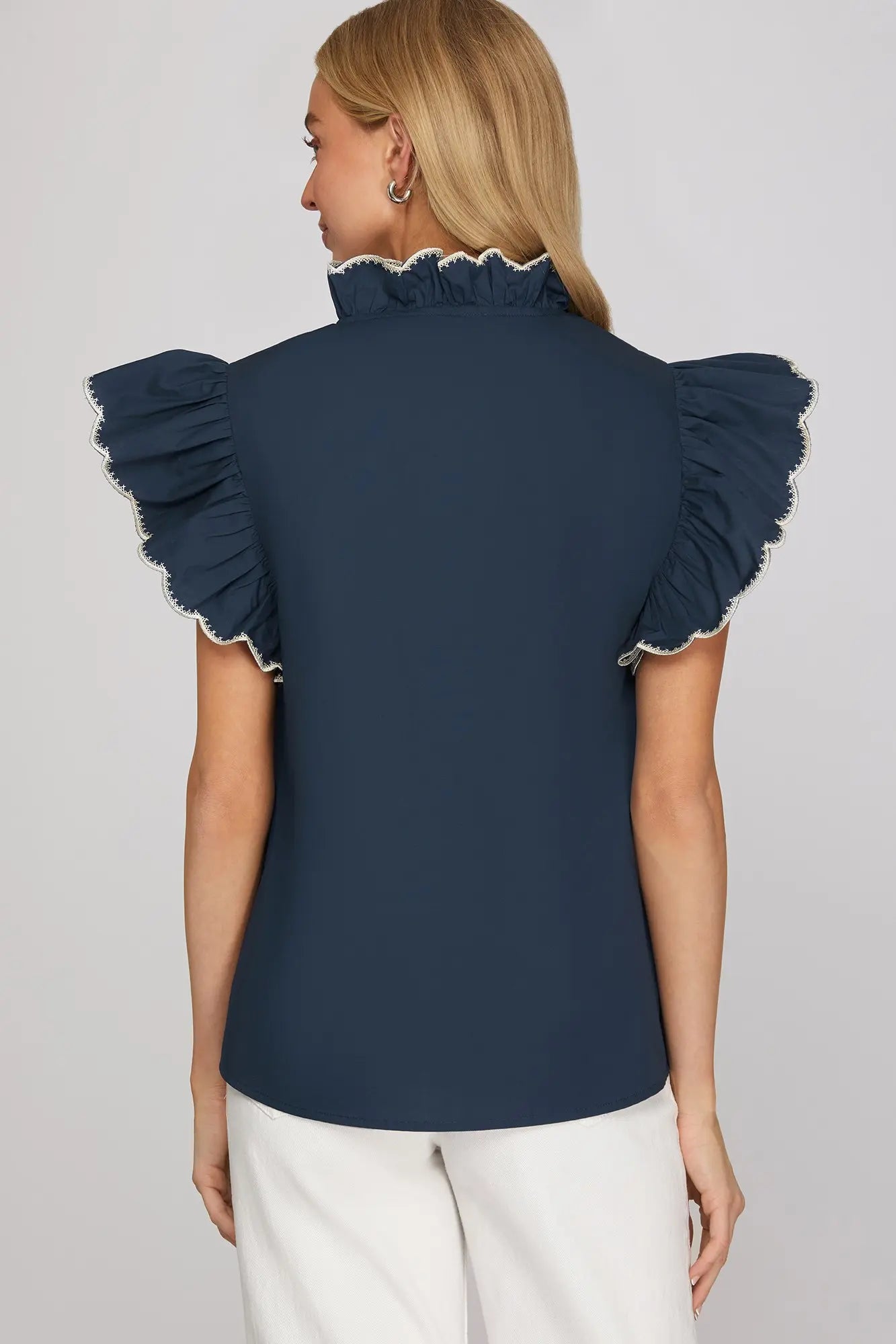 Back of woman wearing a navy blue top with ruffled sleeves