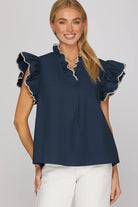 Woman wearing a navy blue top with ruffled sleeves