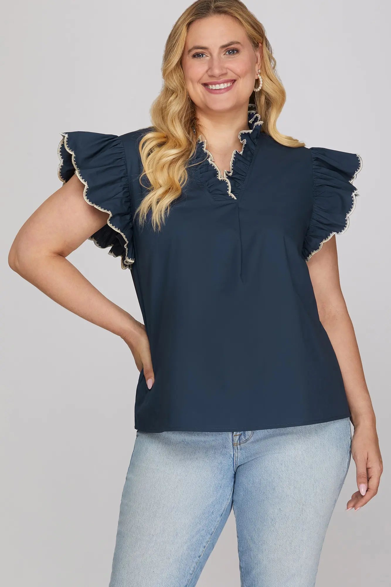 Woman wearing a navy blue top with ruffled sleeves 