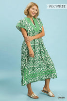 Woman wearing a green patterned dress on a blue background