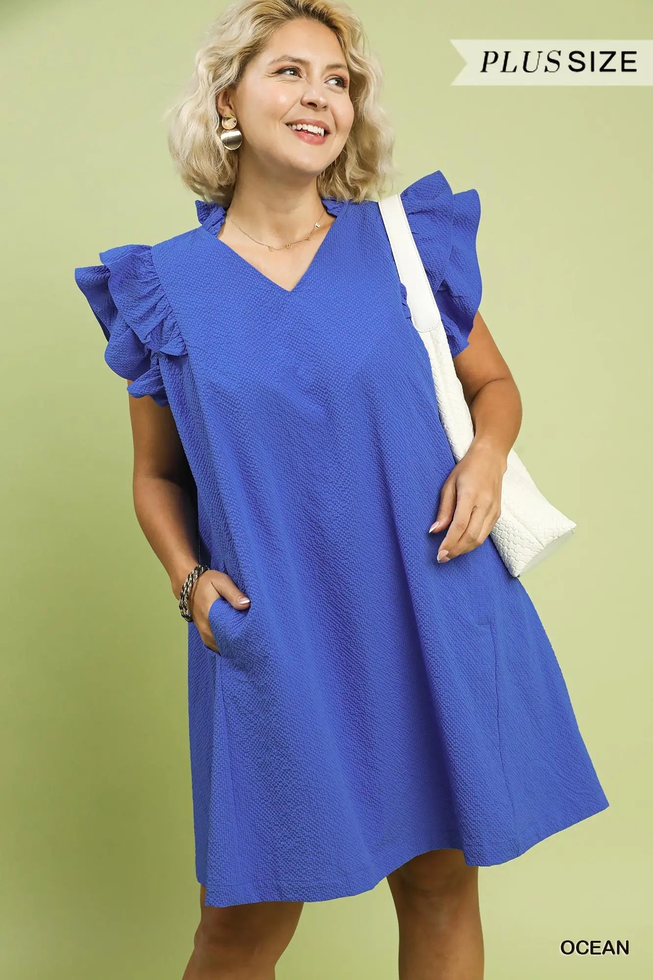 Woman wearing a blue dress with ruffled sleeves