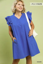 Woman wearing a blue dress with ruffled sleeves