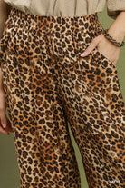 Leopard print pants worn by a person with a green background