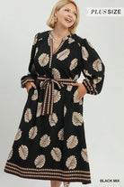 A woman modeling a black long-sleeve maxi dress with a beige palm leaf pattern and a matching tie belt, shown against a light gray studio background with 'PLUS SIZE' text in the top right.