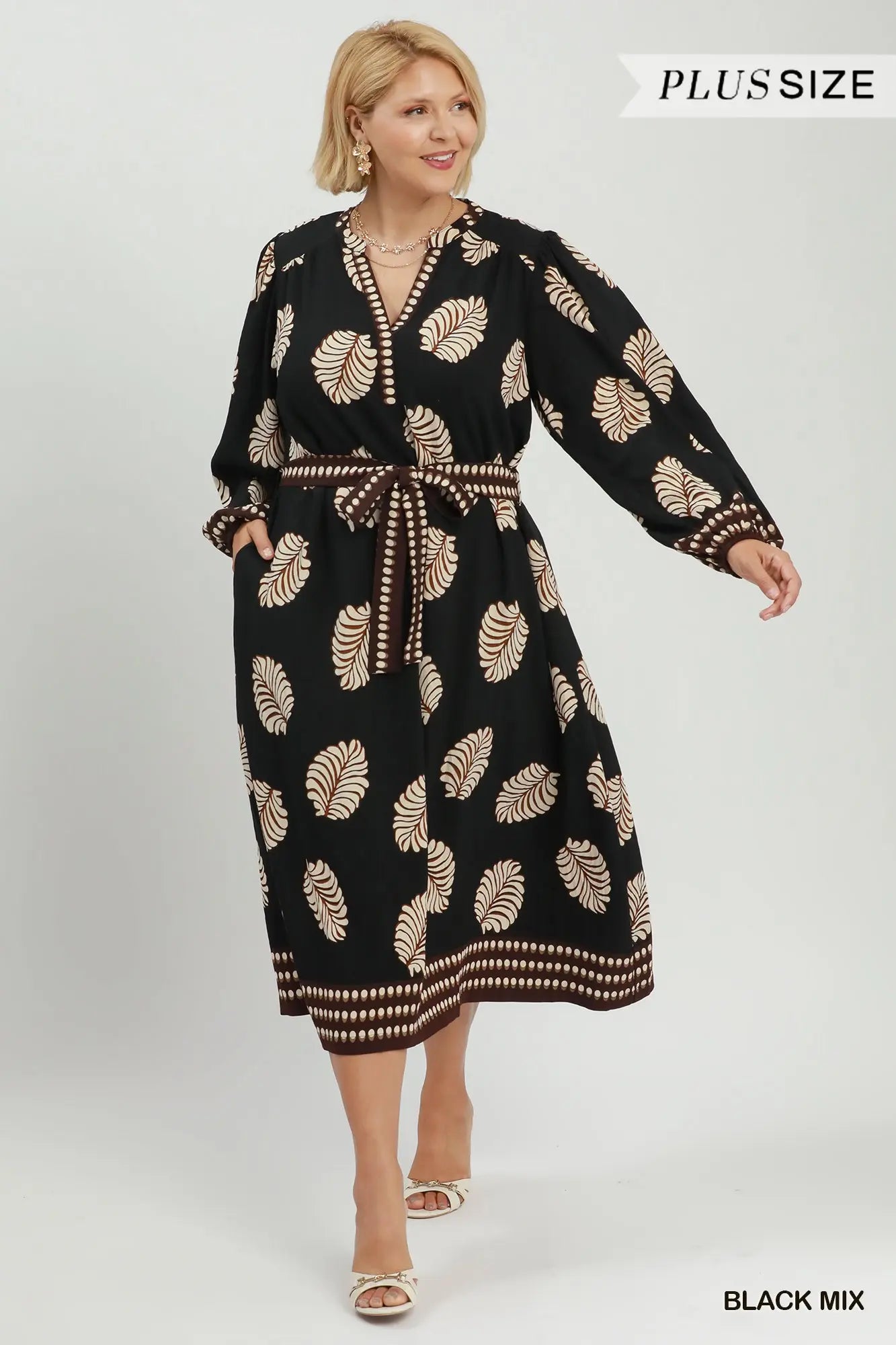 A woman modeling a black long-sleeve midi dress with a beige palm leaf pattern and a matching tie belt, shown against a light gray studio background. Text overlays read 'PLUS SIZE' and 'BLACK MIX'.
