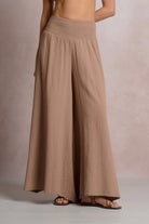 Brown wide-leg pants worn by a person on a neutral background