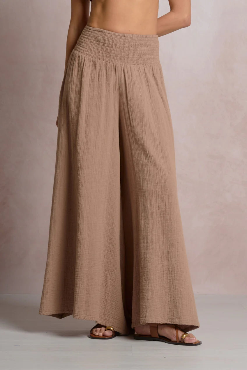 Brown wide-leg pants worn by a person on a neutral background