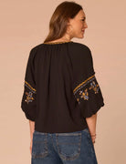 Back view of woman wearing black shirt and jeans 