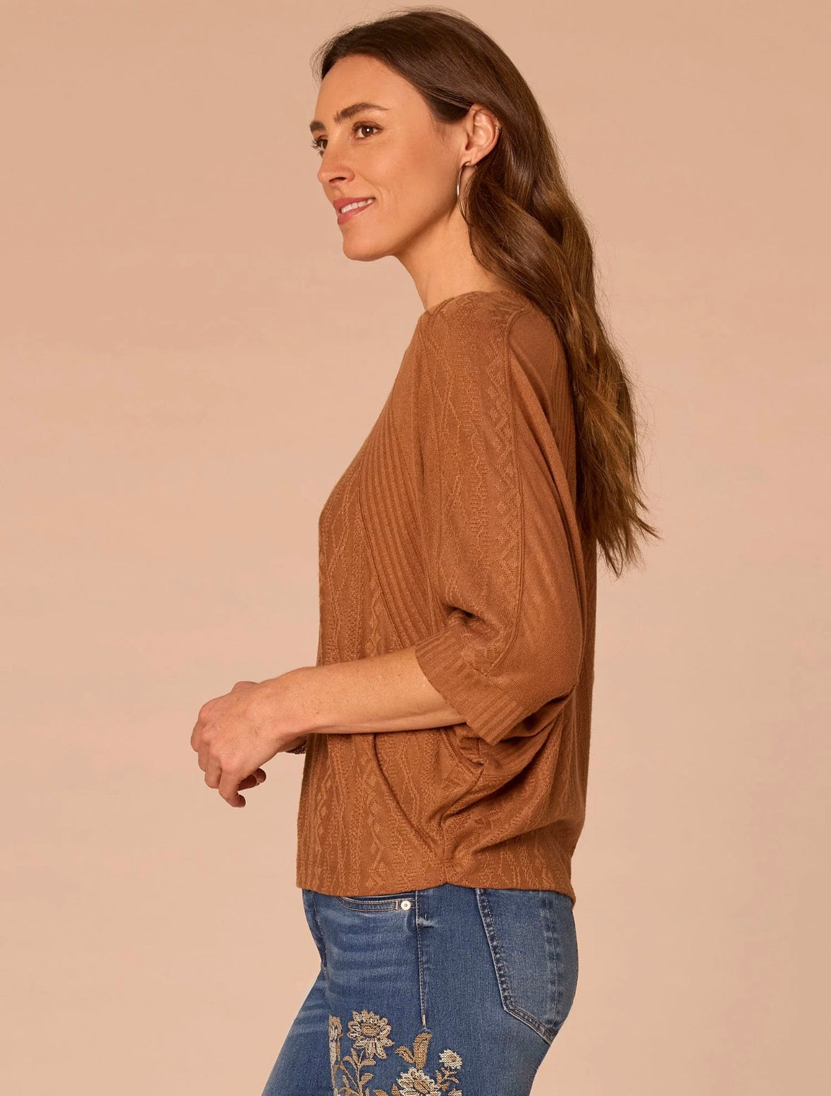 Side view of woman  wearing rust colored shirt 