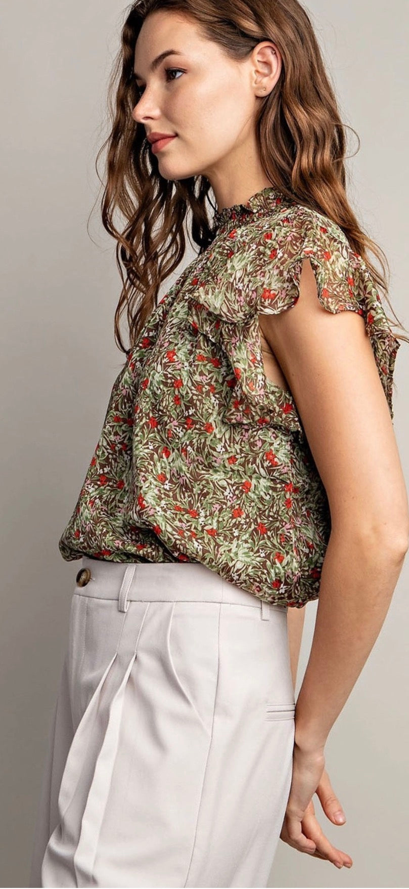 Model wearing olive floral tank with white pants