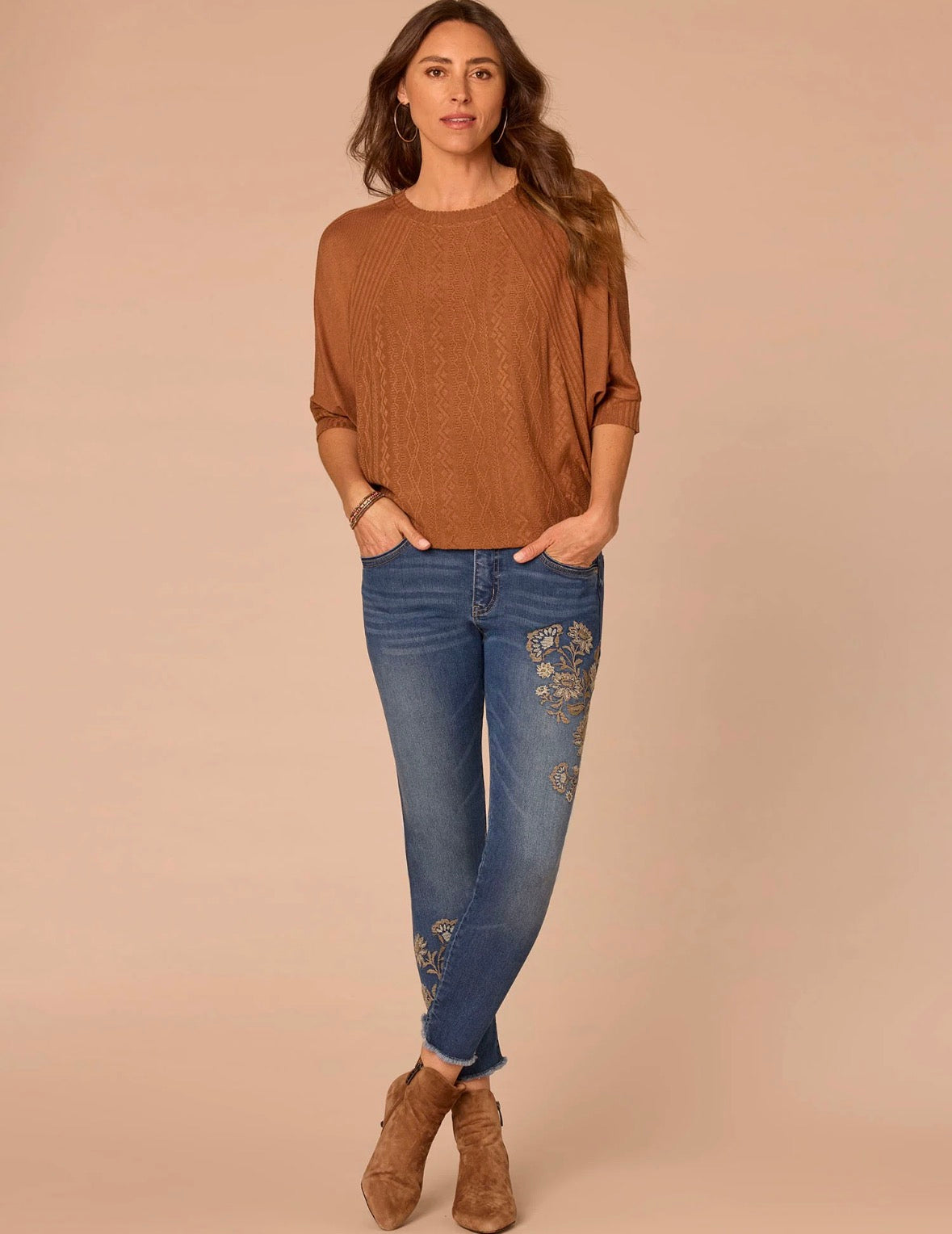 Woman wearing rust colored shirt and jeans 