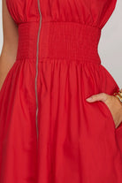 Red dress with a close-up of the waistband and fabric texture.
