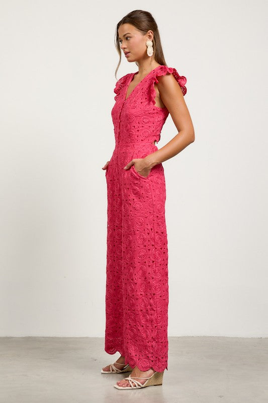 Woman wearing a pink lace dress with ruffled shoulders side view