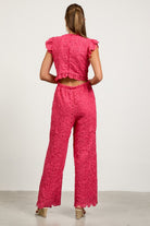 Woman wearing a pink lace outfit back view 