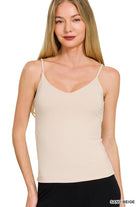 Woman wearing a beige camisole against a white background