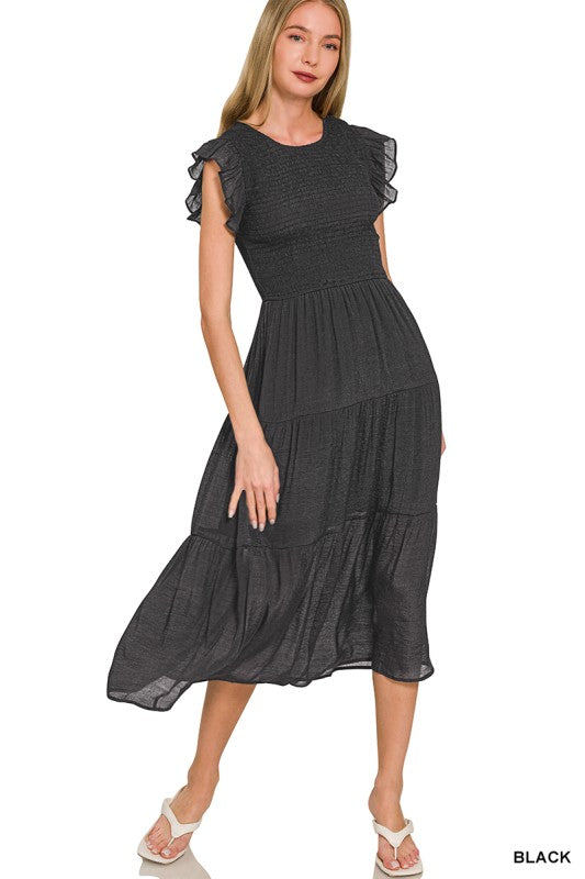 Woman wearing a black dress with ruffled sleeves