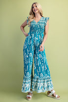 Woman wearing a blue patterned jumpsuit on a green background