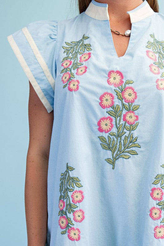 Light blue dress with floral embroidery on a plain background
