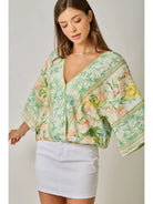 Woman wearing a floral kimono-style top with a plain background