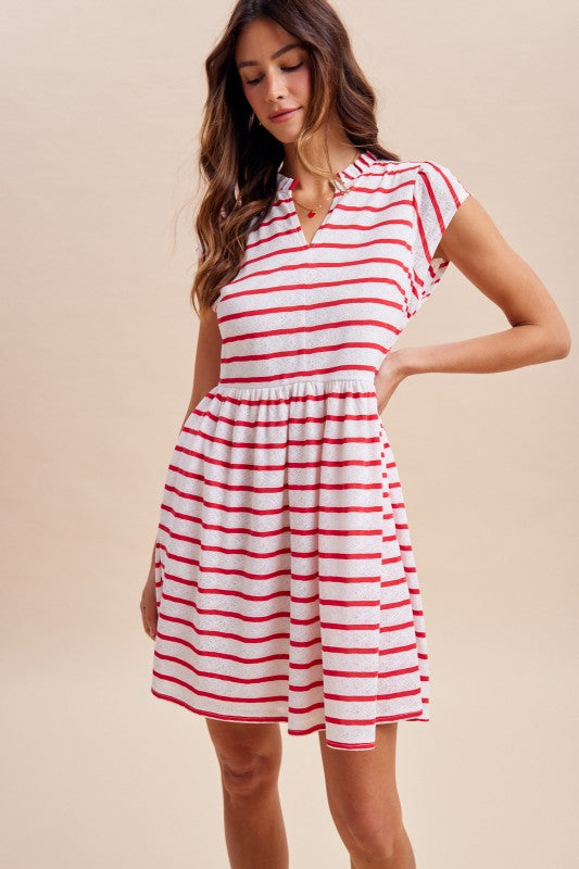 Woman wearing a red and white striped dress against a beige background