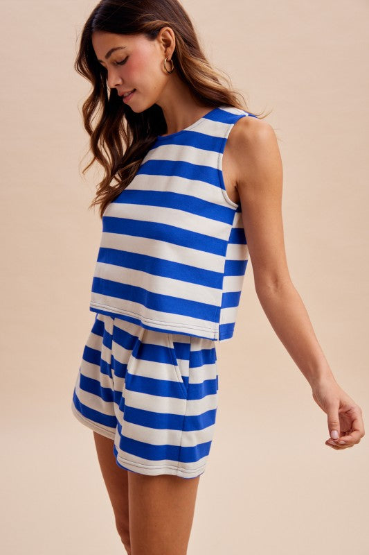 Woman wearing a blue and white striped set against a beige background