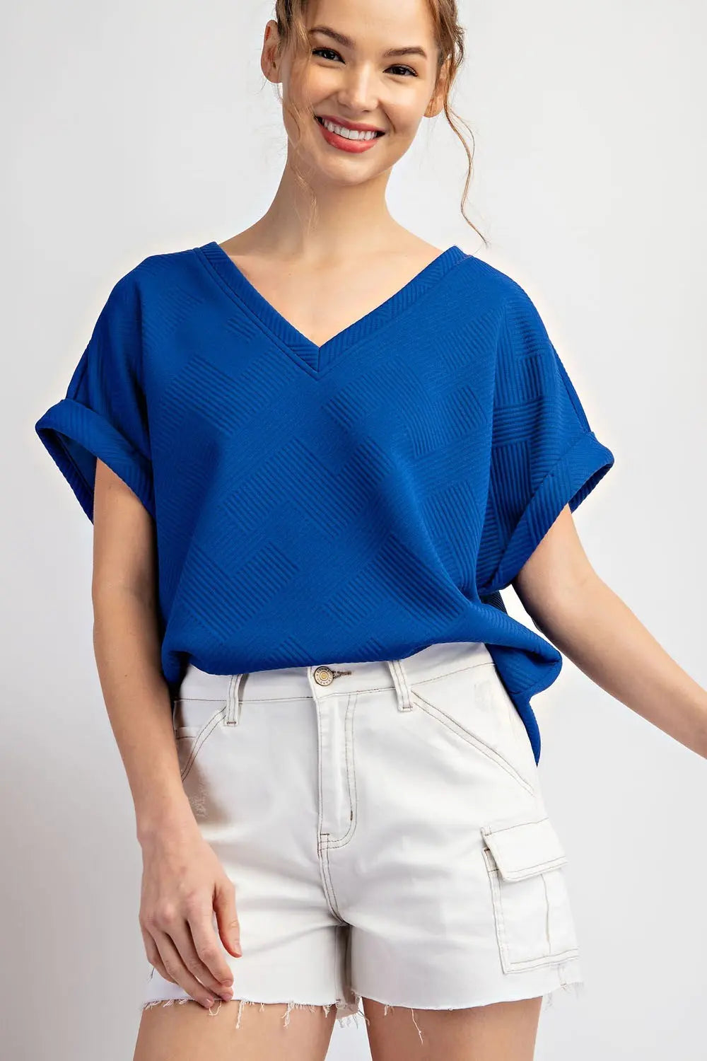 Model wearing blue top with white frayed shorts