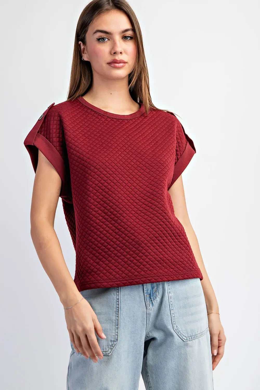 Textured maroon shirt with light jeans on a white background