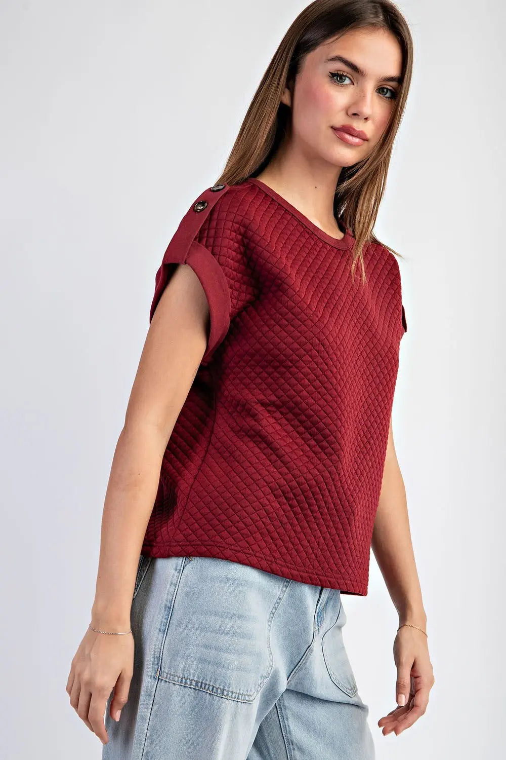 Side view of textured maroon shirt with light jeans