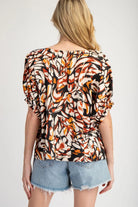 Back view of model wearing printed blouse and Jean cut off shorts