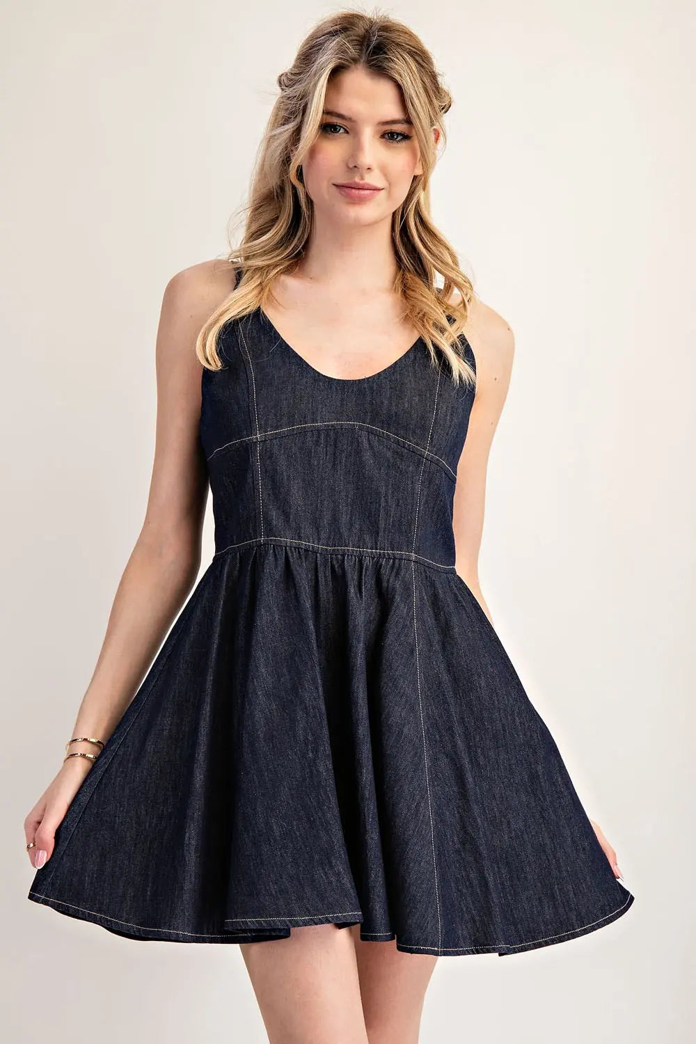Model wearing dark denim dress with skirt flared