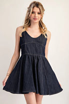Model wearing dark denim dress with skirt flared