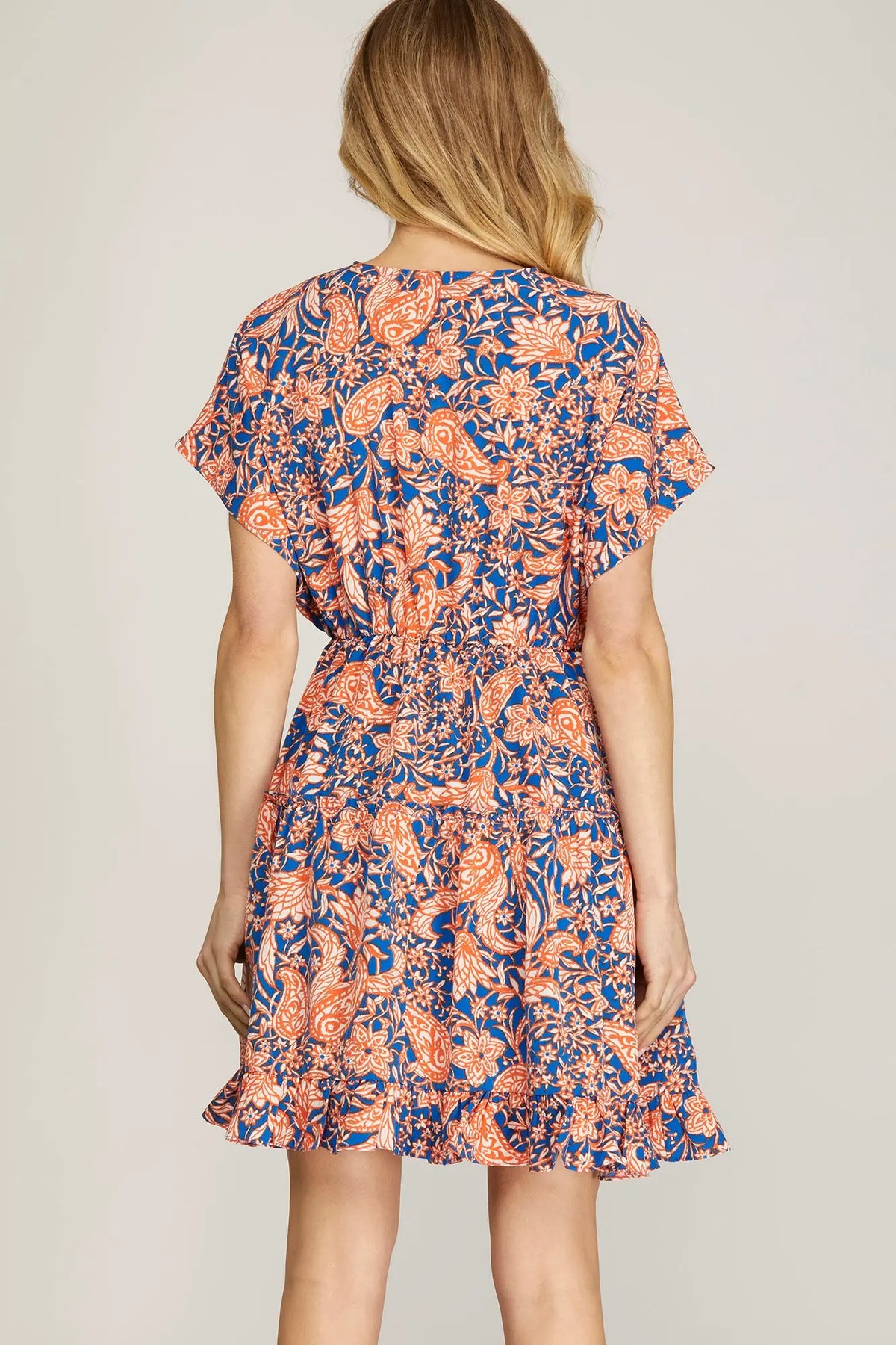 Back view of model, wearing orange and blue dress