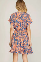 Back view of model, wearing orange and blue dress