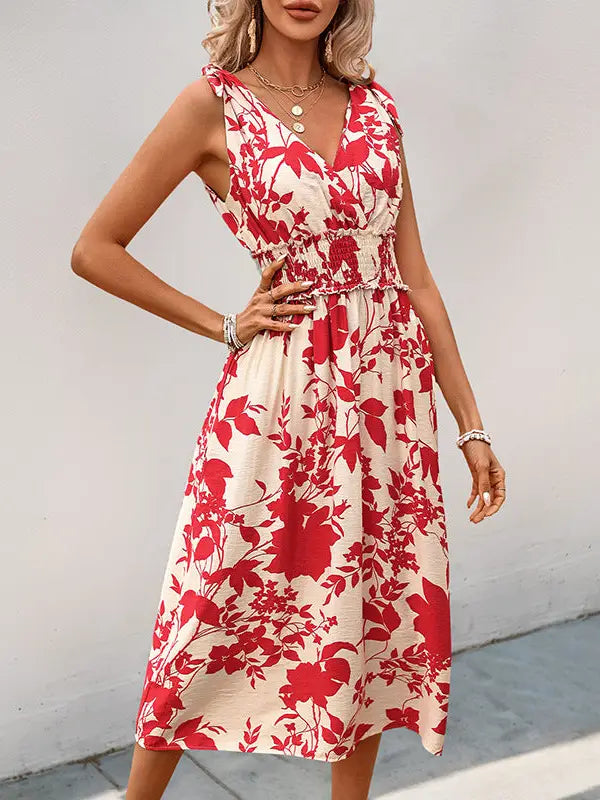Woman wearing a red and white floral dress against a plain background
