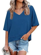 Woman wearing a blue oversized t-shirt and denim shorts on a white background