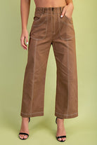 Brown wide-leg pants worn by a person on a green background