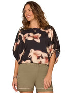 Model wearing dolman top and shorts on a white background. 