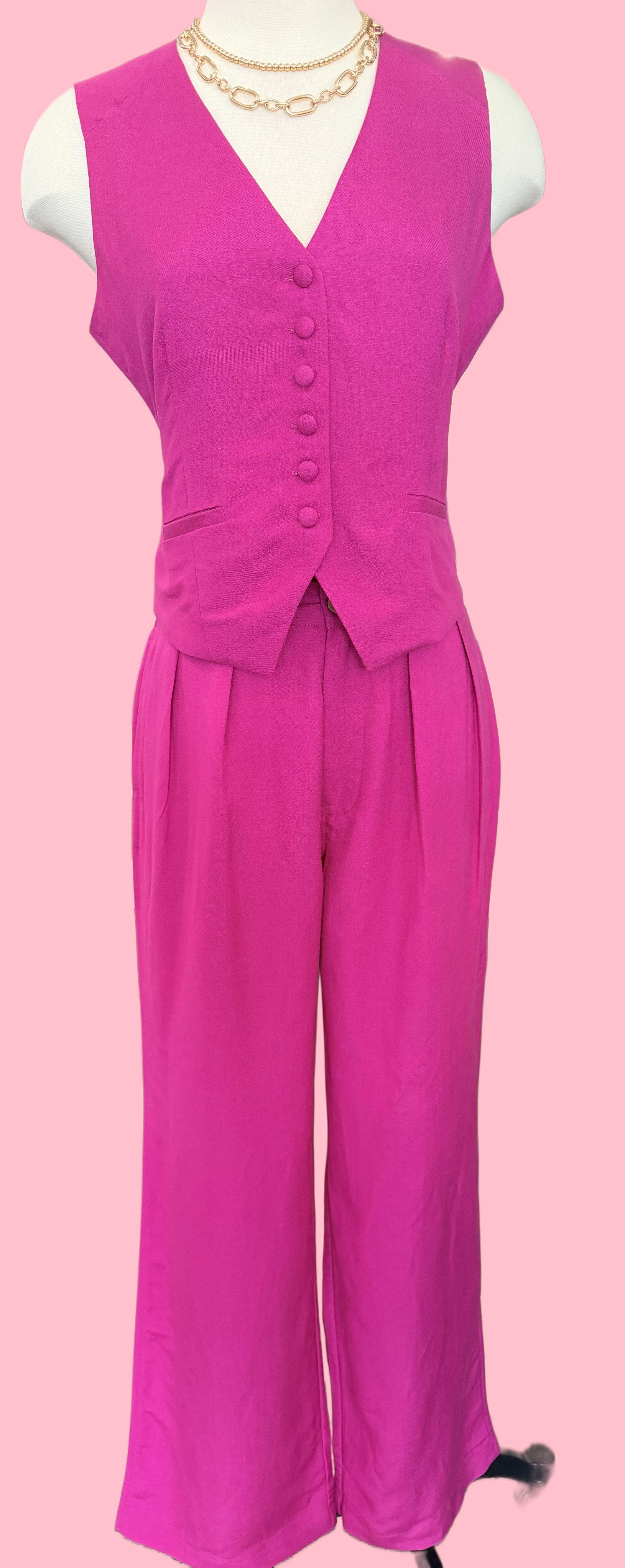 Pink sleeveless top and wide-leg pants on a mannequin against a pink background