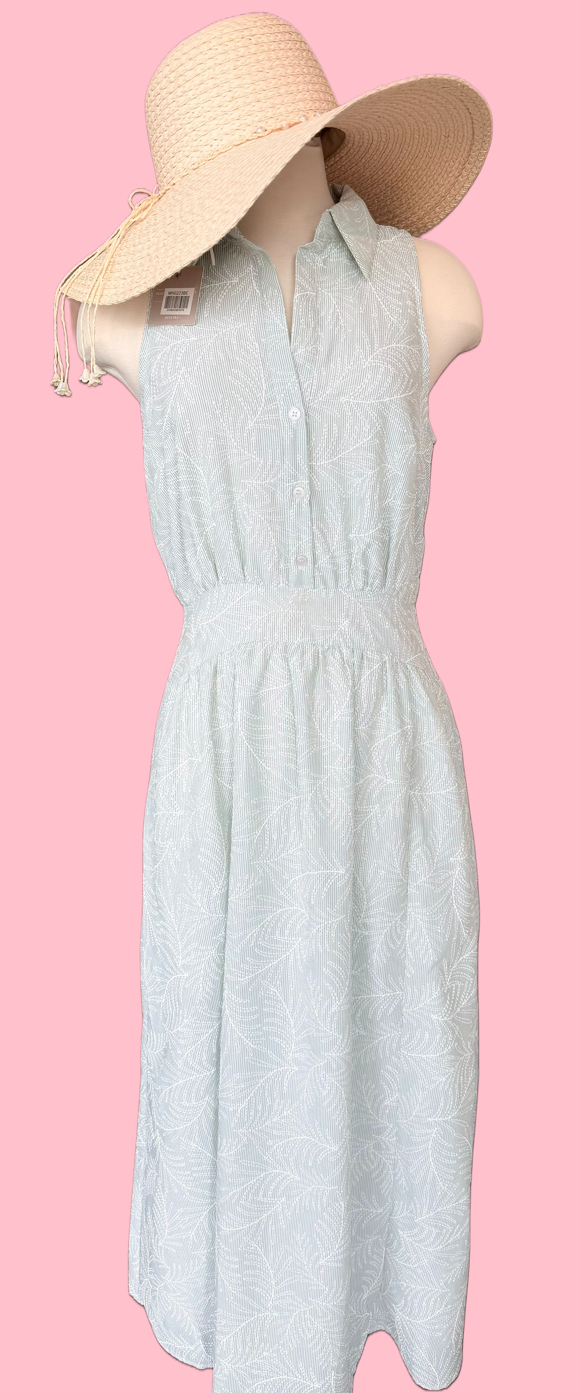 Light green dress with a beige sun hat on a pink background