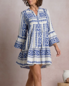 Woman wearing a blue and white patterned dress against a plain background