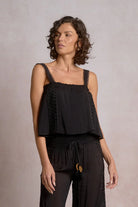 Woman wearing a black sleeveless top with lace details 
